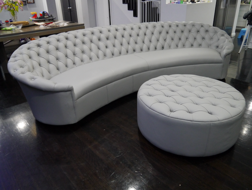 Curved leather buttoned lounge with matching ottoman
