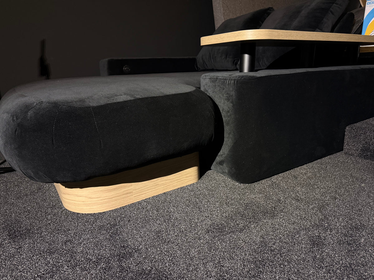 Real custom DreamCloud detail showing rounded upholstered seat, timber plinth and floating table on a dark upright.