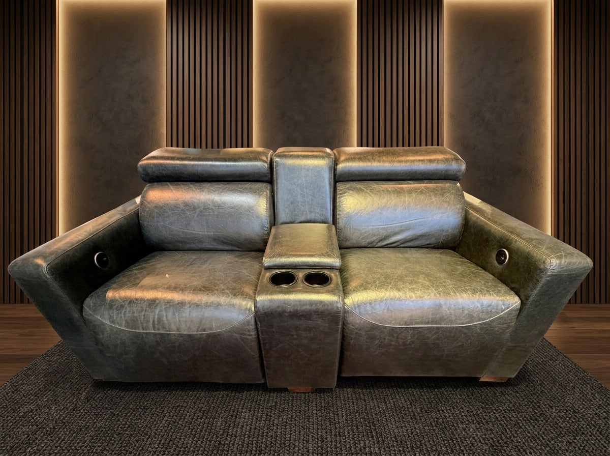 Maximus 2-Seater Electric Headrest Recliner with centre console and cup holders upholstered in distressed olive-charcoal leather in a home theatre room.